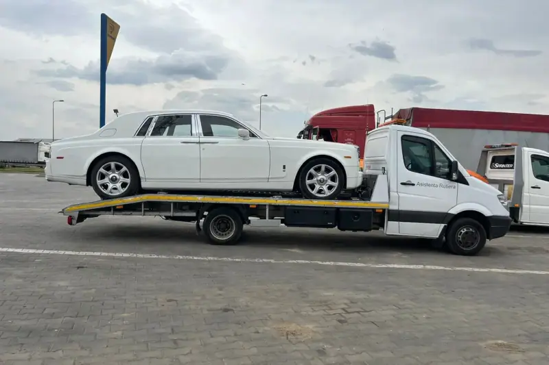 Autoturism sedan pe platformă de tractări auto