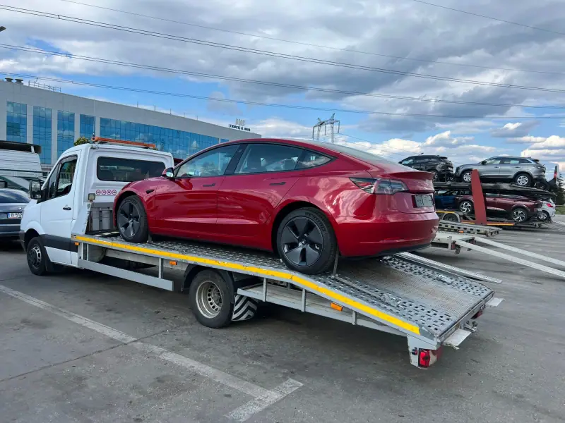 Mașină electrică pe platformă de tractări auto